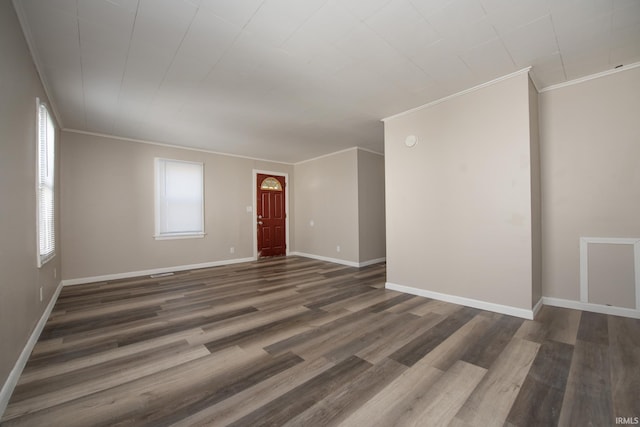 unfurnished living room featuring ornamental molding, wood finished floors, and baseboards