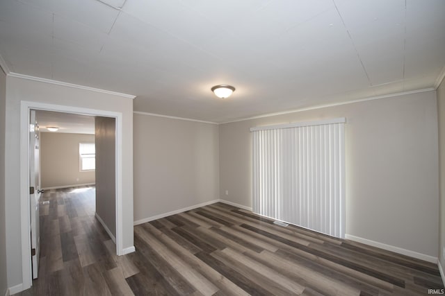 unfurnished room featuring ornamental molding, dark wood finished floors, and baseboards