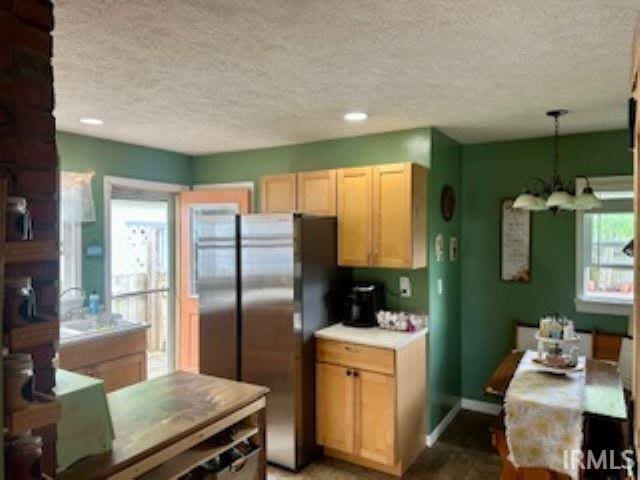 kitchen with a chandelier, a textured ceiling, freestanding refrigerator, light countertops, and decorative light fixtures