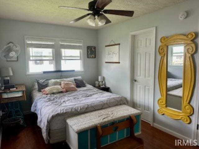 bedroom with wood finished floors, a textured ceiling, and ceiling fan