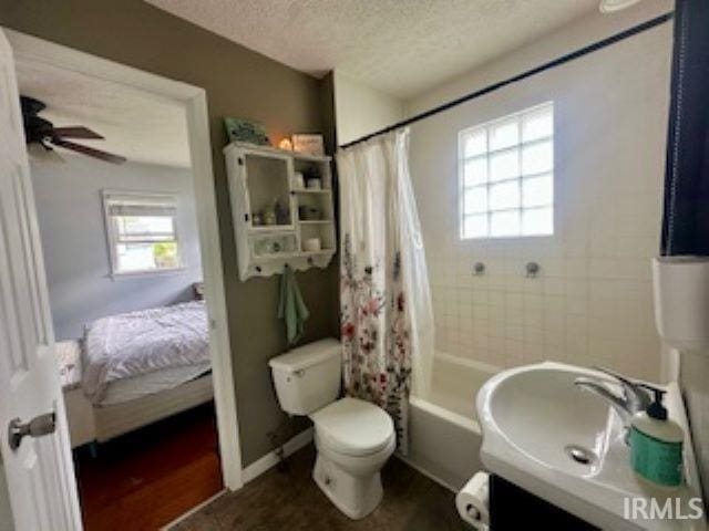 full bathroom featuring plenty of natural light, a textured ceiling, toilet, a sink, and shower / tub combo with curtain