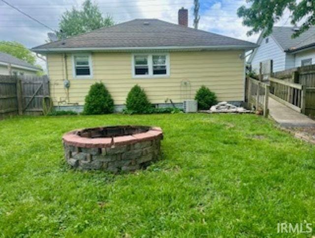 rear view of property with a fire pit and a chimney