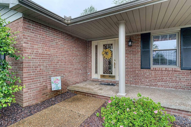 view of exterior entry with brick siding
