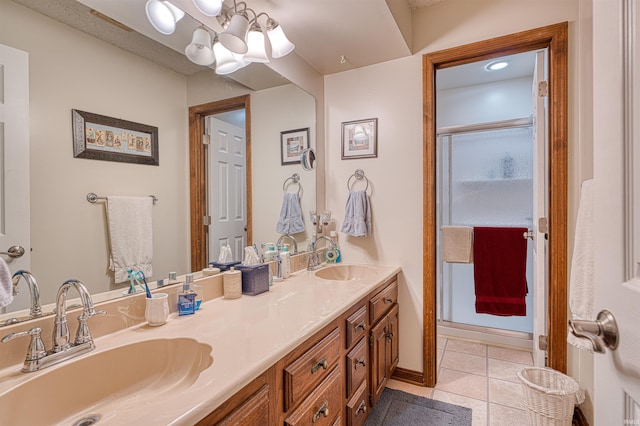 full bathroom featuring a chandelier, double vanity, tile patterned floors, baseboards, and a shower with shower door