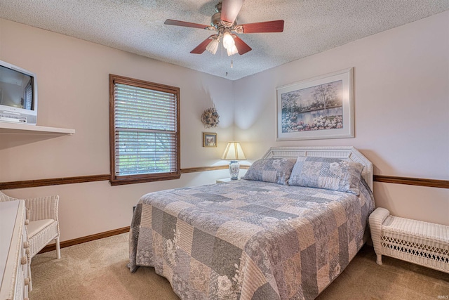 bedroom featuring carpet flooring, a textured ceiling, a ceiling fan, and baseboards