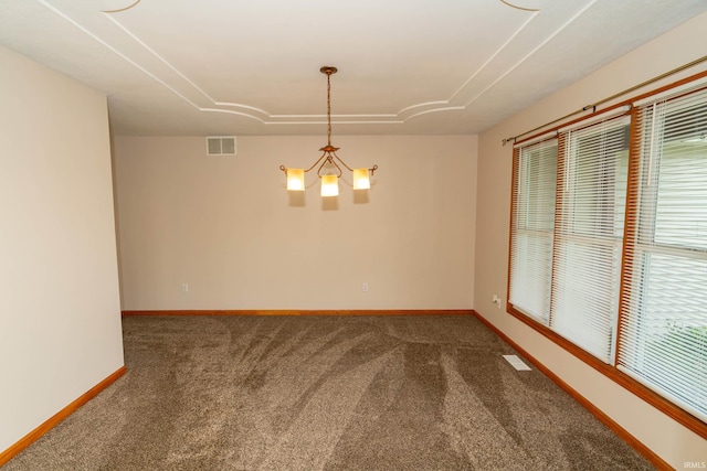 unfurnished room with carpet floors, baseboards, and a chandelier