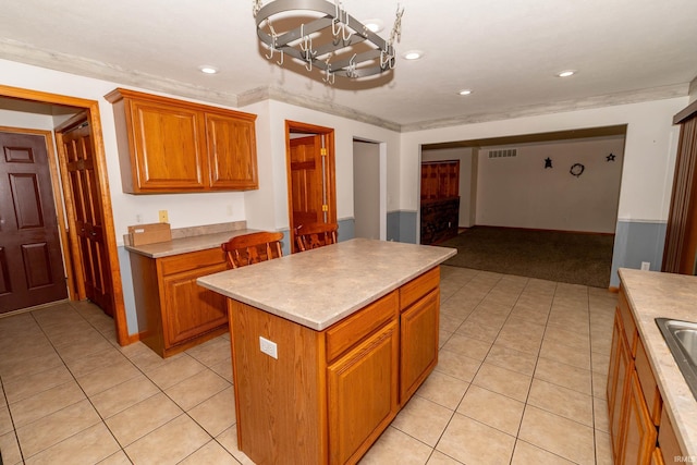 kitchen featuring a chandelier, light tile patterned floors, a center island, light colored carpet, and light countertops