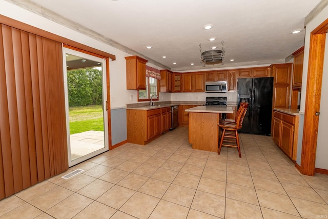 kitchen with stainless steel appliances, brown cabinetry, recessed lighting, light countertops, and a kitchen breakfast bar