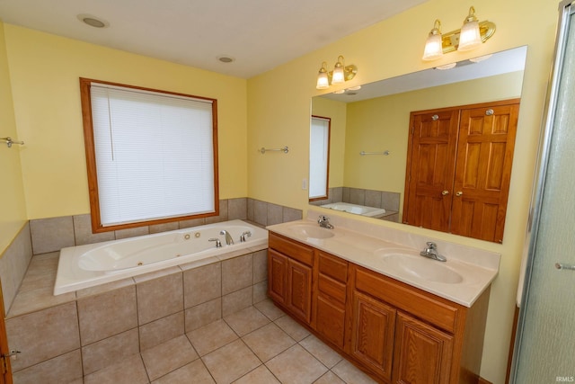 full bathroom featuring a jetted tub, double vanity, and tile patterned flooring