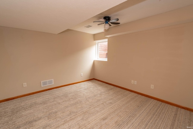 spare room with ceiling fan, baseboards, and light colored carpet