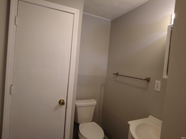 4702 N 37th Hwy, Bedford, IN 47421 - bathroom featuring a textured ceiling, toilet, a sink, and ornamental molding