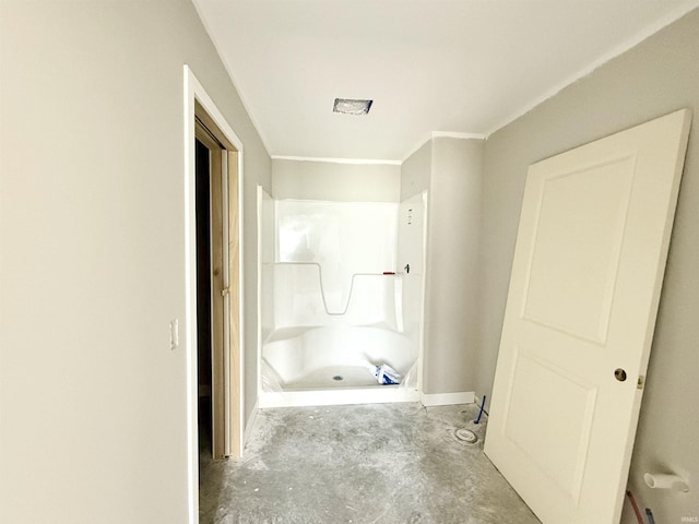 bathroom with concrete flooring, a shower, and crown molding