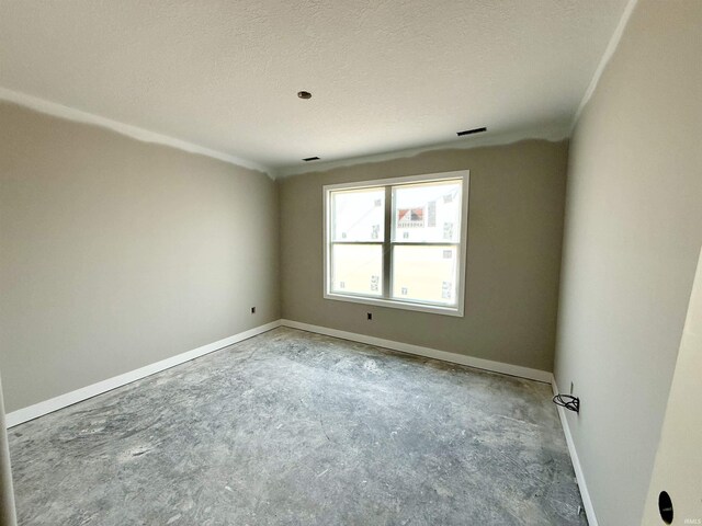 empty room featuring a textured ceiling and baseboards