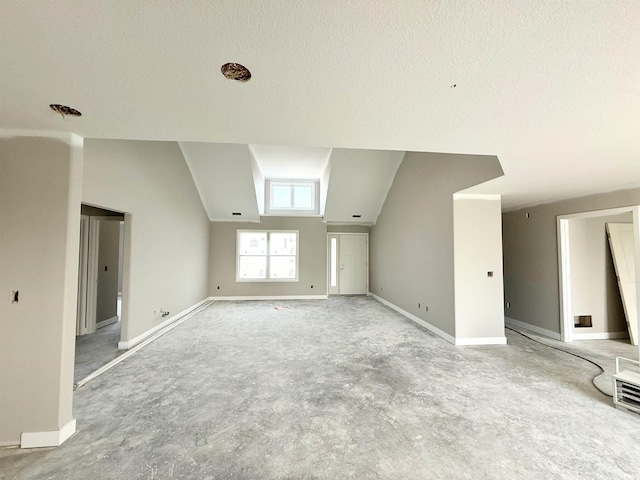 bonus room featuring lofted ceiling, baseboards, and a textured ceiling