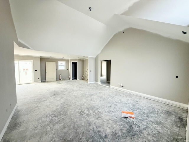 unfurnished living room featuring baseboards, carpet floors, and high vaulted ceiling