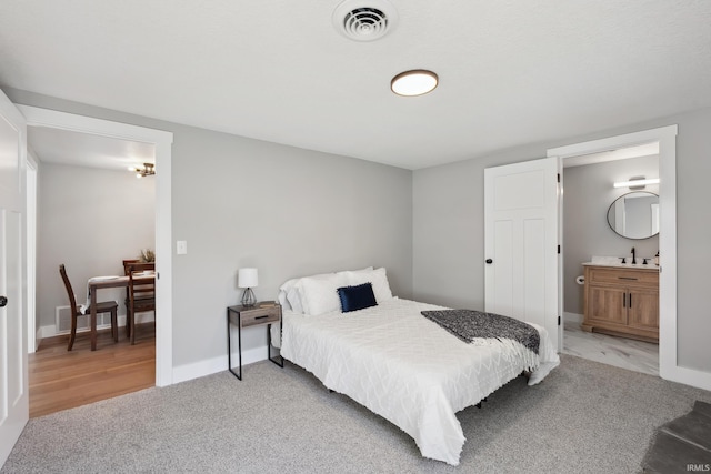 5363 W Warren Ave, Silver Lake, IN 46982 - bedroom with light carpet, a sink, connected bathroom, and baseboards