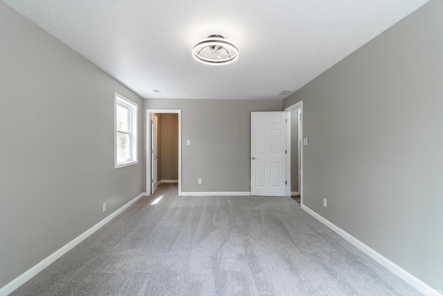 unfurnished bedroom with baseboards and carpet