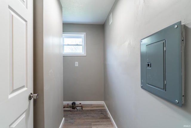washroom featuring electric panel, wood finished floors, and baseboards