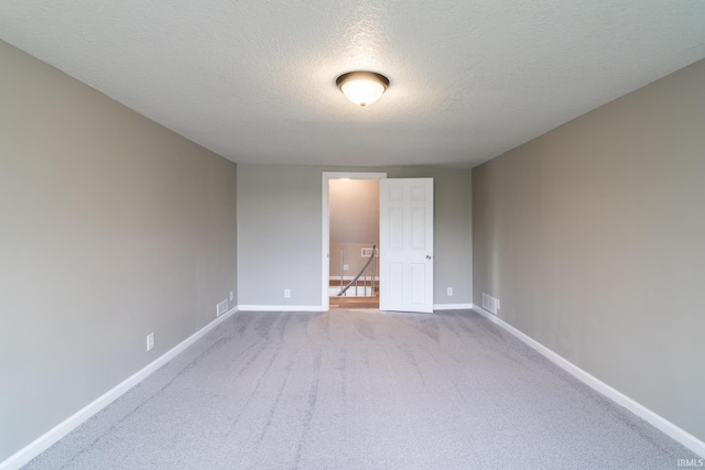 unfurnished bedroom with a textured ceiling, carpet floors, and baseboards