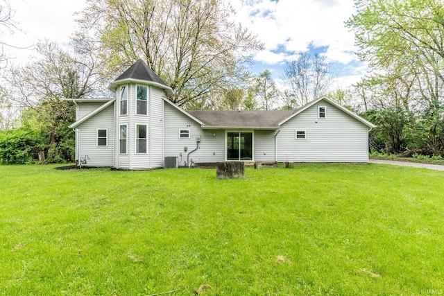 back of house featuring a lawn and central air condition unit