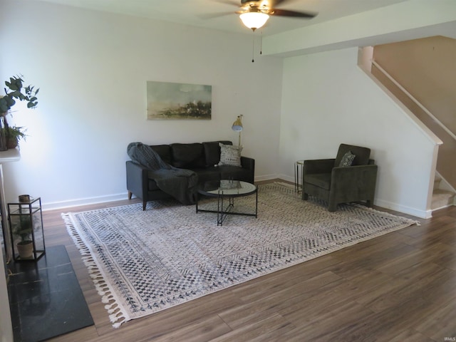 living room featuring stairway, wood finished floors, a ceiling fan, and baseboards