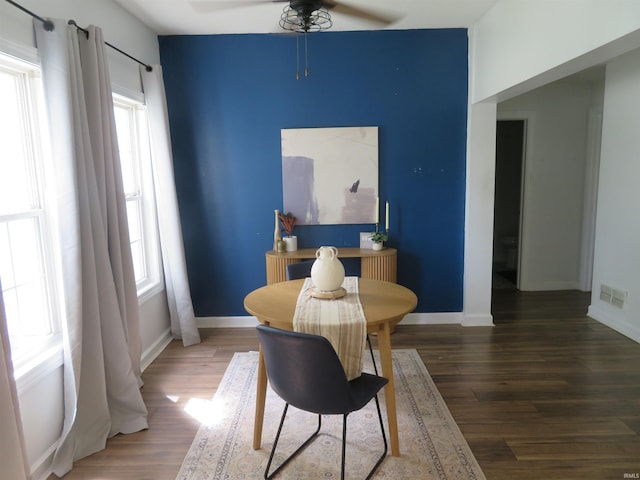 dining space featuring ceiling fan, wood finished floors, and baseboards