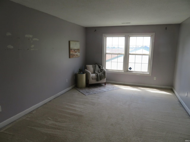 unfurnished room featuring carpet floors and baseboards