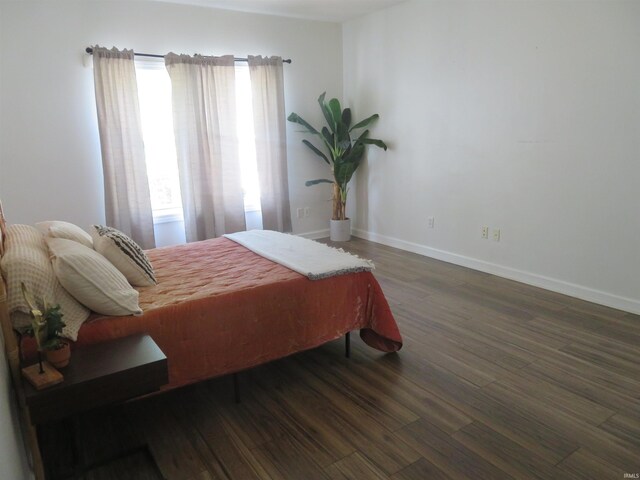 bedroom featuring wood finished floors and baseboards