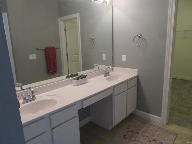 bathroom featuring tile patterned floors, double vanity, and baseboards