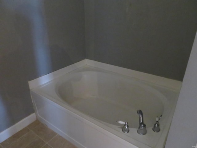 full bathroom featuring a bath, tile patterned flooring, and baseboards