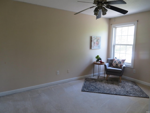 sitting room featuring ceiling fan, carpet, and baseboards