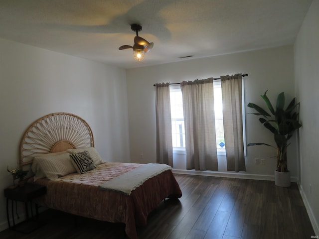 bedroom featuring dark wood finished floors, ceiling fan, and baseboards