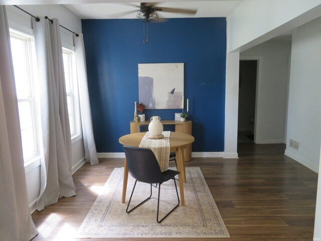 dining room with a ceiling fan, wood finished floors, and baseboards