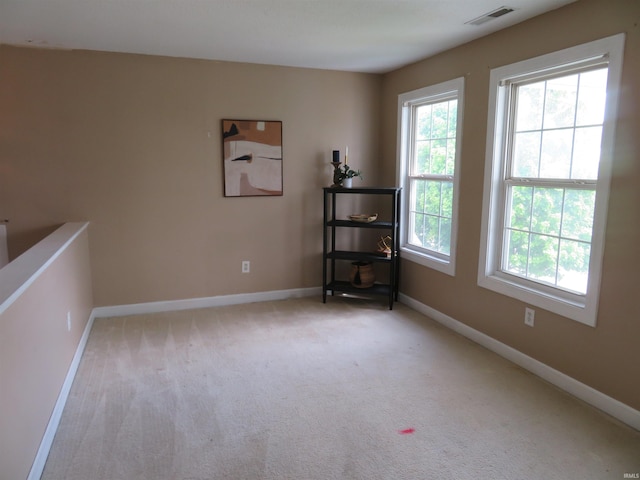 empty room with plenty of natural light, baseboards, and carpet flooring
