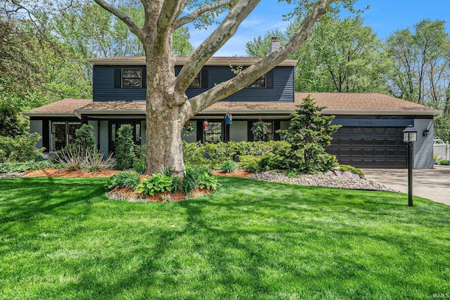 view of front of home featuring a garage, a chimney, a front lawn, and driveway