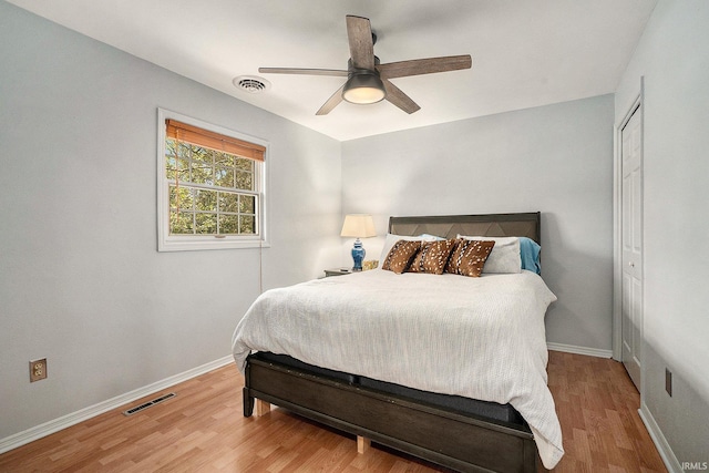 bedroom with wood finished floors, baseboards, a closet, and a ceiling fan
