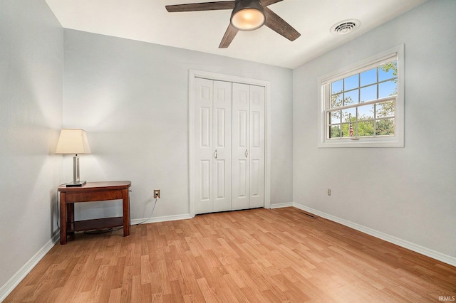 unfurnished bedroom with light wood-type flooring, baseboards, a closet, and ceiling fan