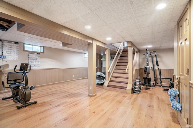 exercise room featuring wainscoting, wood finished floors, and recessed lighting