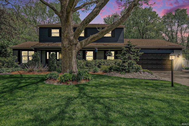 view of front of home with a garage, concrete driveway, a yard, and a chimney