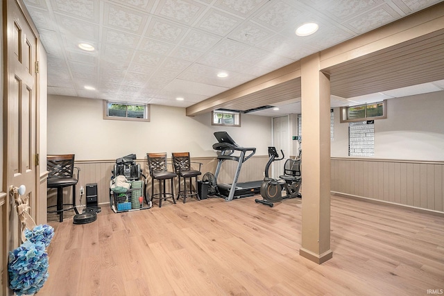 workout room featuring wood finished floors, wainscoting, and recessed lighting