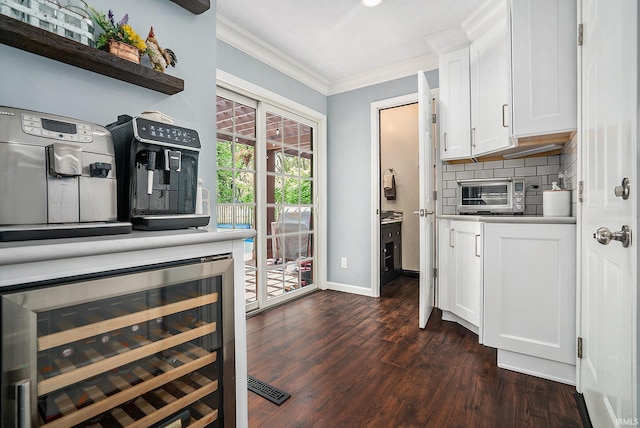 kitchen with beverage cooler, crown molding, dark wood-type flooring, white cabinetry, and decorative backsplash