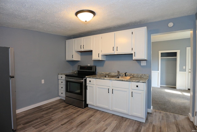 455 E Barner St, Frankfort, IN 46041 - kitchen featuring appliances with stainless steel finishes, a sink, dark wood-style floors, white cabinetry, and a textured ceiling