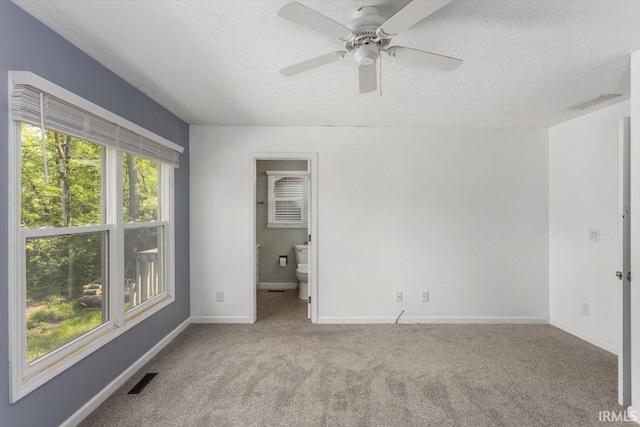 unfurnished bedroom with carpet flooring, a textured ceiling, baseboards, and ceiling fan