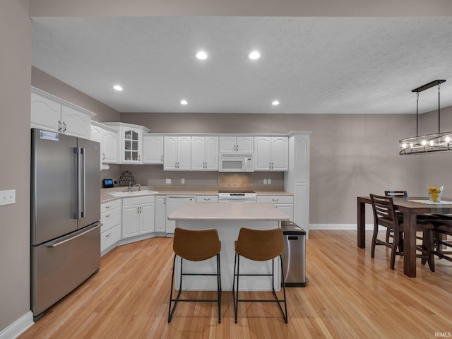 1745 Mill Pond Ln, Lafayette, IN 47905 - kitchen featuring white appliances, light wood-type flooring, light countertops, white cabinets, and baseboards