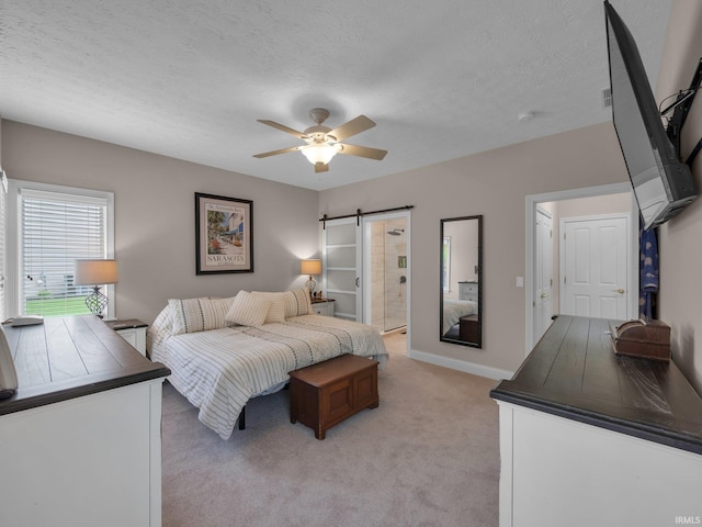 1745 Mill Pond Ln, Lafayette, IN 47905 - bedroom with a barn door, light colored carpet, a textured ceiling, a ceiling fan, and connected bathroom
