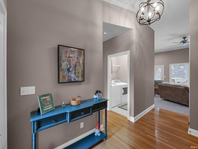 1745 Mill Pond Ln, Lafayette, IN 47905 - corridor featuring separate washer and dryer, wood finished floors, a chandelier, baseboards, and crown molding