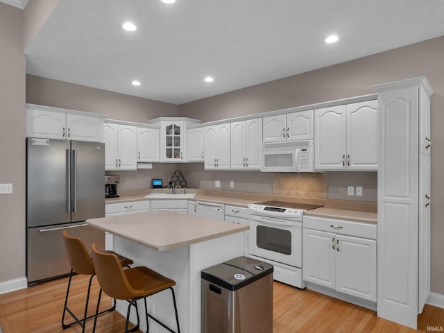 1745 Mill Pond Ln, Lafayette, IN 47905 - kitchen with white appliances, a sink, a breakfast bar area, white cabinets, and light countertops
