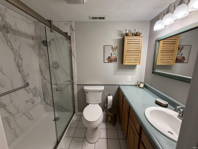 9607 S Lake Ridge Dr, Bloomington, IN 47401 - bathroom featuring a marble finish shower, vanity, toilet, a textured ceiling, and wainscoting
