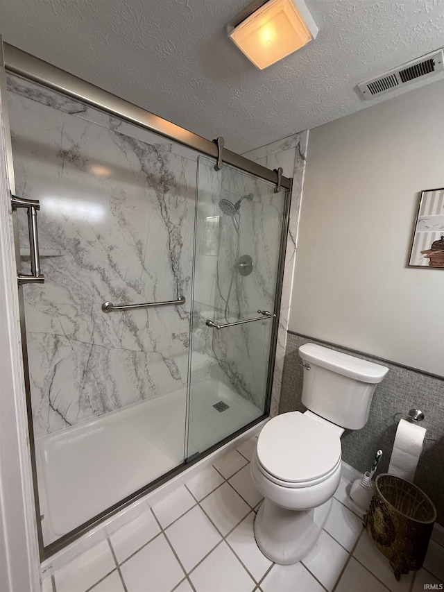 9607 S Lake Ridge Dr, Bloomington, IN 47401 - bathroom with a marble finish shower, toilet, a textured ceiling, and wainscoting