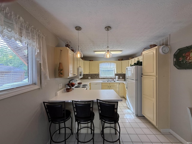 9607 S Lake Ridge Dr, Bloomington, IN 47401 - kitchen with white appliances, a sink, a peninsula, a textured ceiling, and light countertops